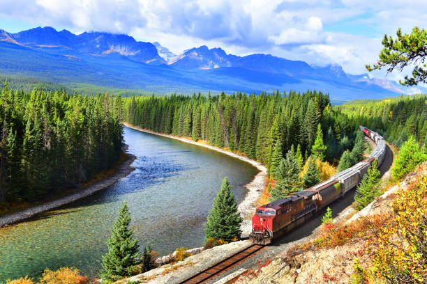 Luxurious train traveling through the Canadian Rockies peaks.
